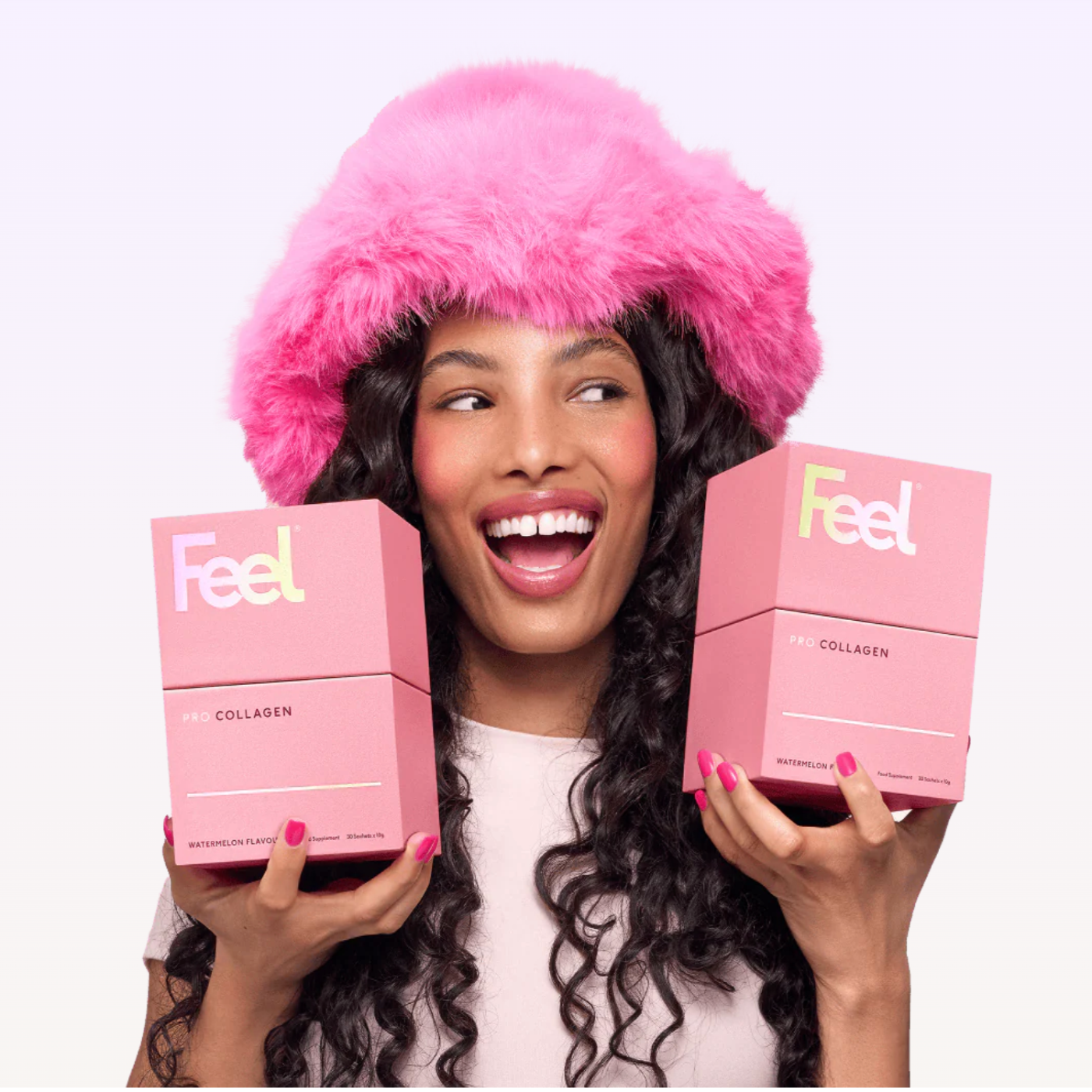 Woman wearing a pink fur hat and holding pink 'Feel' boxes against a white background